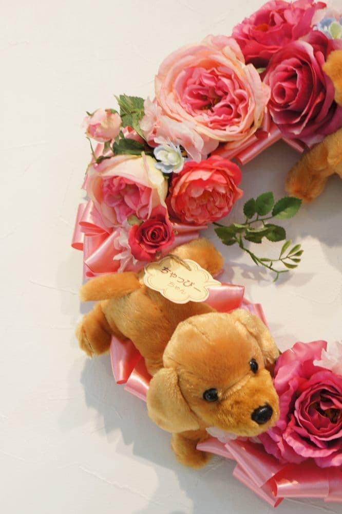 わんこのリース　高級造花専門店アンクラフトは１級フラワー装飾技能士がアーティフィシャルフラワー（造花）を使用し、ご希望のアレンジメント、髪飾り、ブーケをオーダーメイドで制作致します。結婚記念日やお見舞いの花、花言葉に合わせたお花の贈り物や開店花、待合室用、応接用花、個性的な髪飾りや派手な花、大人可愛い、おしゃれなバラなどどんなオーダーでもお気軽にお問い合わせください。大阪、兵庫県、関西からアクセスが簡単。