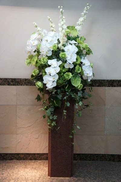 エントランス花　高級造花専門店アンクラフトは１級フラワー装飾技能士がアーティフィシャルフラワー（造花）を使用し、ご希望のアレンジメント、髪飾り、ブーケをオーダーメイドで制作致します。結婚記念日やお見舞いの花、花言葉に合わせたお花の贈り物や開店花、待合室用、応接用花、個性的な髪飾りや派手な花、大人可愛い、おしゃれなバラなどどんなオーダーでもお気軽にお問い合わせください。大阪、兵庫県、関西からアクセスが簡単。